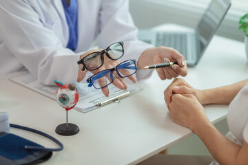 The ophthalmologist lets the patient choose the eyeglass frames that fit their face and sends them...