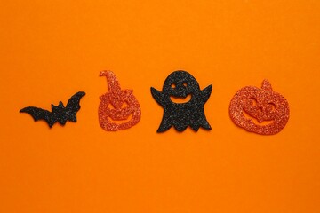 Happy Halloween holiday concept. Halloween festive background design featuring pumpkins, ghost and decorative bat. Top view