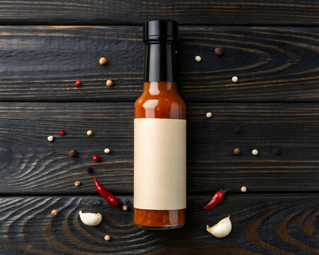 Gourmet hot sauce bottle with simple label on dark wood