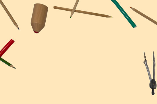 different colored wooden pencils laying around on clean pastel background