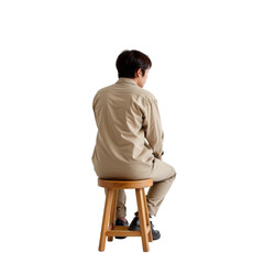 Individual Sitting on Stool in Casual Clothing with Hair Styled Neatly from the Back on White Background