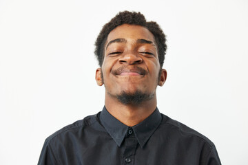 A joyful black man smiling brightly, showcasing happiness and confidence. His casual attire...