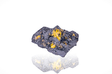 Yellow Sturmanite on black Manganite. Specimen from N'Chwaning 2, South Africa. photography isolated on white blackground. macro detail background. close-up mineral crystal unpolished