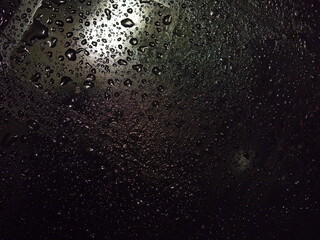 Complex texture of many droplets on black with dim light. Closeup