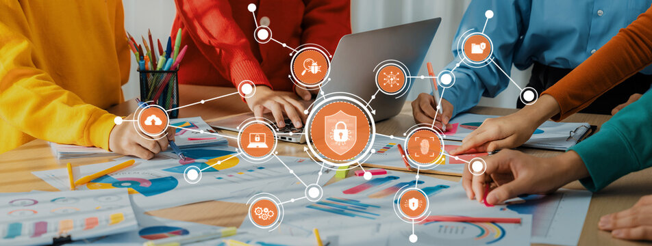 A diverse group of professionals collaborate on cybersecurity strategies, surrounded by colorful materials and digital icons representing communication and data protection efforts. Amity