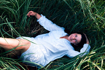 Portrait, rest and a woman lying on grass outdoor in nature during summer for peace or quiet on a...