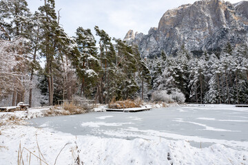 A snowy landscape with a frozen lake and a wooden dock