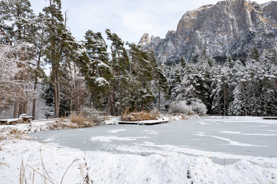 A snowy landscape with a frozen lake and a wooden dock