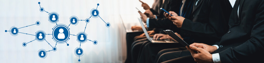 Group of professionals engaged in networking while using mobile devices, showcasing a digital connection graphic that represents modern communication and collaboration. Amity