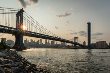 Scenic view of Manhattan Bridge with the sun setting over New York City skyline