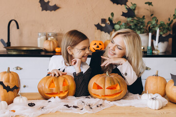 Mother and daughter carving pumpkins for Halloween party