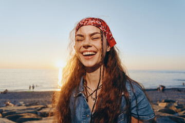 Lifestyle woman in modern boho-western denim street style smiling on sunny beach with warm film...