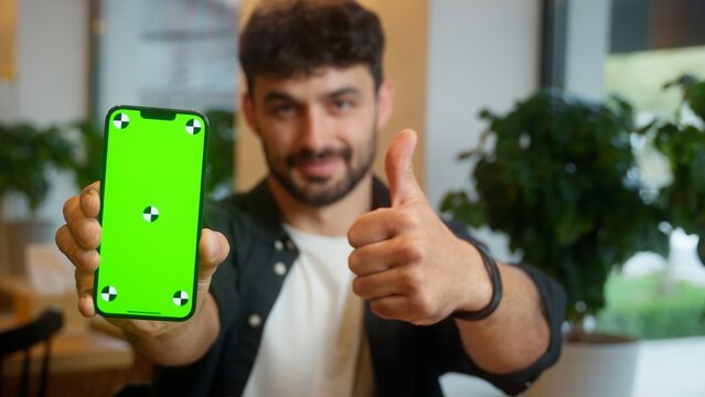 Caucasian man showing mobile phone green screen smartphone advertising display chroma key male thumb up guy cafe visitor client service recommend app mock up businessman smiling business indoor online - Powered by Adobe