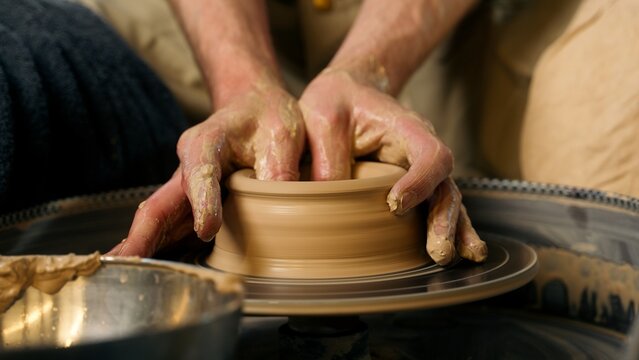 Close up hands skilled craftsman man sculpt modeling shape clay pot jug male handmade potter pottery wheel workshop hobby ceramics vase craft small business owner art arms working earthenware ceramist