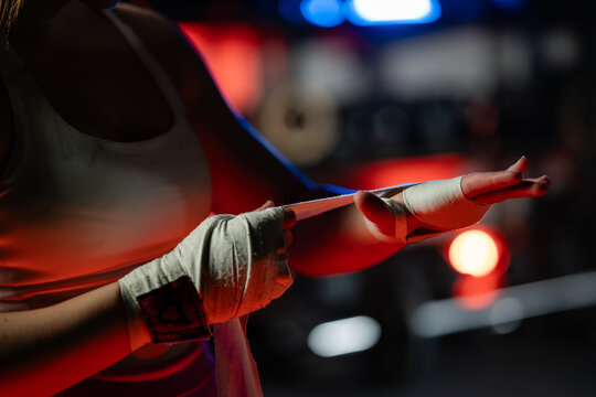 Female boxer wrapping hands getting ready for training in boxing ring - Powered by Adobe