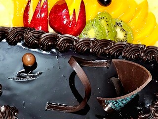 Birthday cake of two halves different pieces sponge creamy cake for celebrations, dark chocolate...