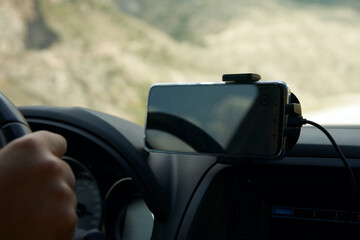  Close-up of a car cabin fragment with a navigator on a smartphone.