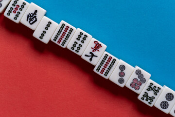 Fototapeta na wymiar 赤と青の背景に並ぶマージャン牌