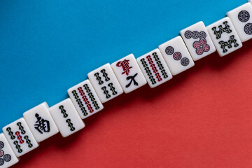 Fototapeta na wymiar 赤と青の背景に並ぶマージャン牌