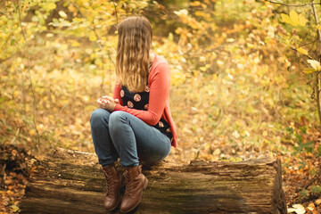 Eine Frau sitzt auf einem Stammbaum.
