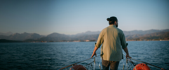 Portrait of a young man on a boat trip on a small ship in the sea on a sunny day.