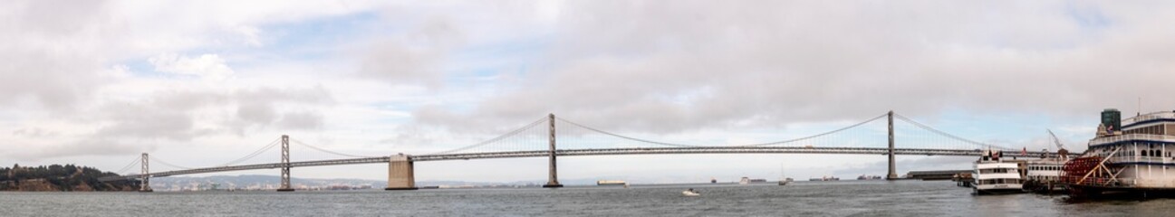 Panoramic view of the Bay Bridge in San Francisco on a cloudy day.
