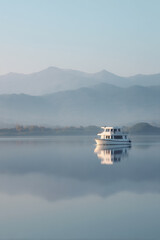 Obraz premium A serene and minimalist landscape depicting a tranquil cruise route, featuring calm waters and distant mountains under a clear sky.
