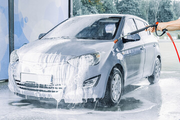 Car wash bubbles. Soap foam water splash. Vehicle spray wet shiny exterior.