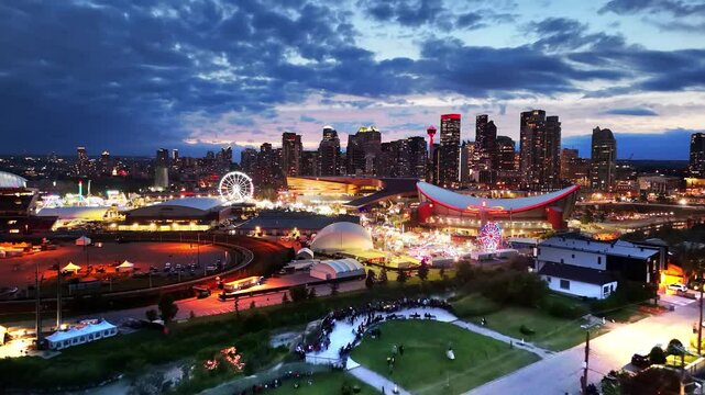 The City of Calgary grounds glow under a dramatic twilight sky, with the city skyline and illuminated attractions captivating the view.