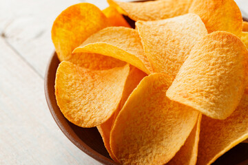 Crispy Potato Chips in Clay Bowl on Rustic Table