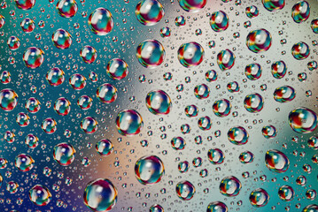 Colorful water drops on glass surface creating abstract macro pattern