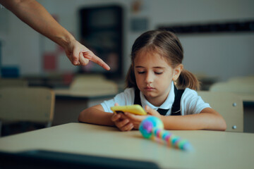 Teacher Scolds Student for Using Phone During Class. Misbehaving schoolchild breaking the rules...