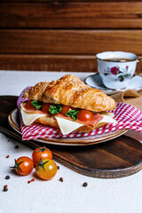 breakfast with coffee and croissant, tomato bacon and cheese