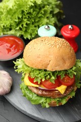Delicious hamburger with patty served on black table, closeup