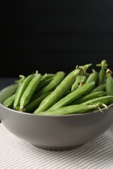 Fresh ripe green peas on black wooden table, closeup