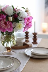 Beautiful table setting with bouquet of peonies indoors, closeup