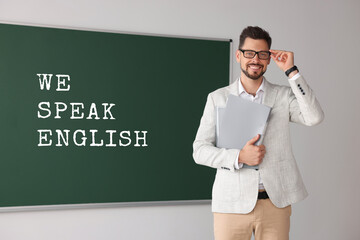 Teacher near green chalkboard with text We Speak English. Language course