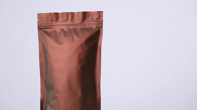Zipper stand-up pouch spinning on light grey background, closeup. Space for text