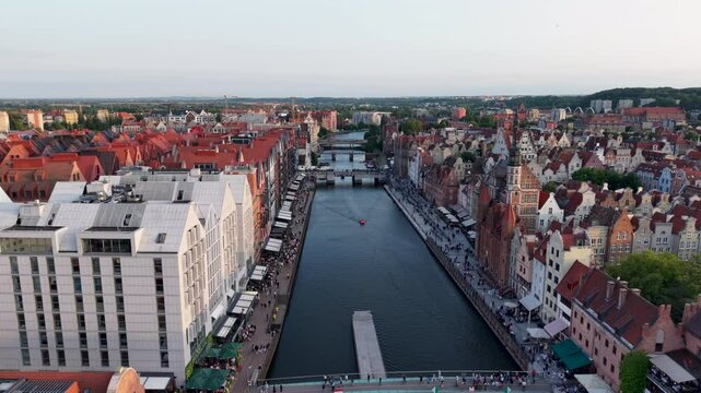 Aerial drone shot above Gdansk Moltlawa River, view of the city old town architecture and walkways by the river, Poland. Slow motion	