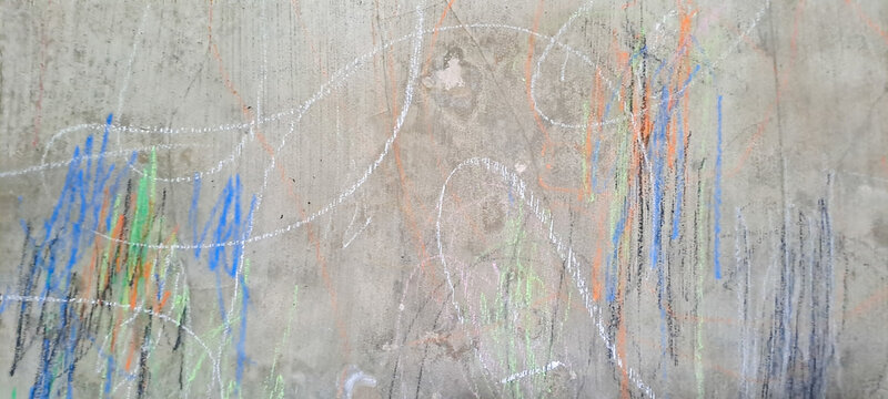 Child scribble on the wall with colored pencil marks on a wall created by a little kid. Child's abstract painting on the wall with colorful patterns	
