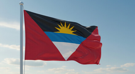 Naklejka premium The flag of Antigua and Barbuda fluttering calmly in the morning breeze, isolated against a soft blue sky.