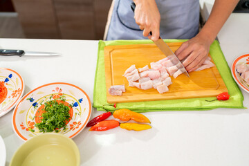 Chef cutting fish for peruvian ceviche preparation in kitchen