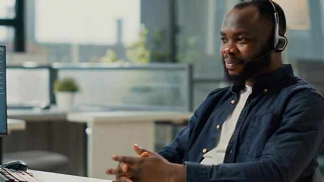 A Black man, dressed in casual attire, sits at a desk, using a landline telephone. He is calmly explaining a return process to a customer service representative.
