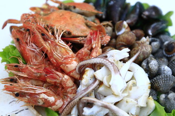 Shrimp, mussels, cockles, crabs, squid, grilled and prepared on a plate, ready to eat.