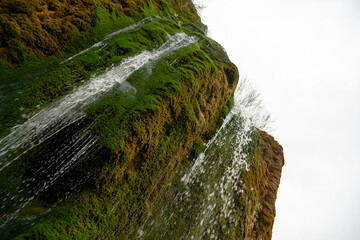 A waterfall is flowing down a rock