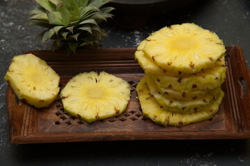 Pineapple juicy yellow slices wooden background. Top view. Pineapple fruit cut on wooden. Chopped...