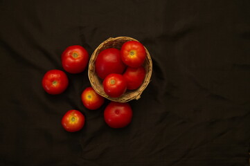 closeup of a red tomato isolated on a black studio background, Tomato isolated. Tomatoes on black background. cherry tomatoes in a wooden bowl isolated.