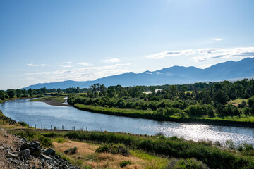 landscape with river and blue sky, mountains