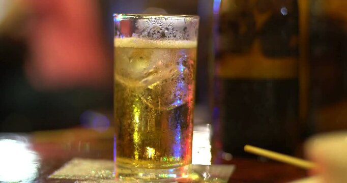 High-quality video of a glass of beer with ice in the foreground.
