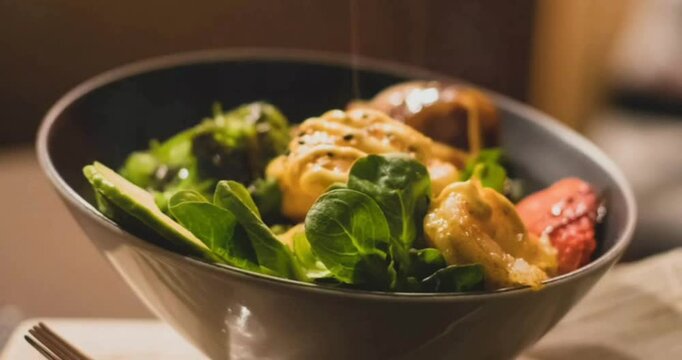 Video of a gray bowl focusing on the food in the foreground with a blurred background
